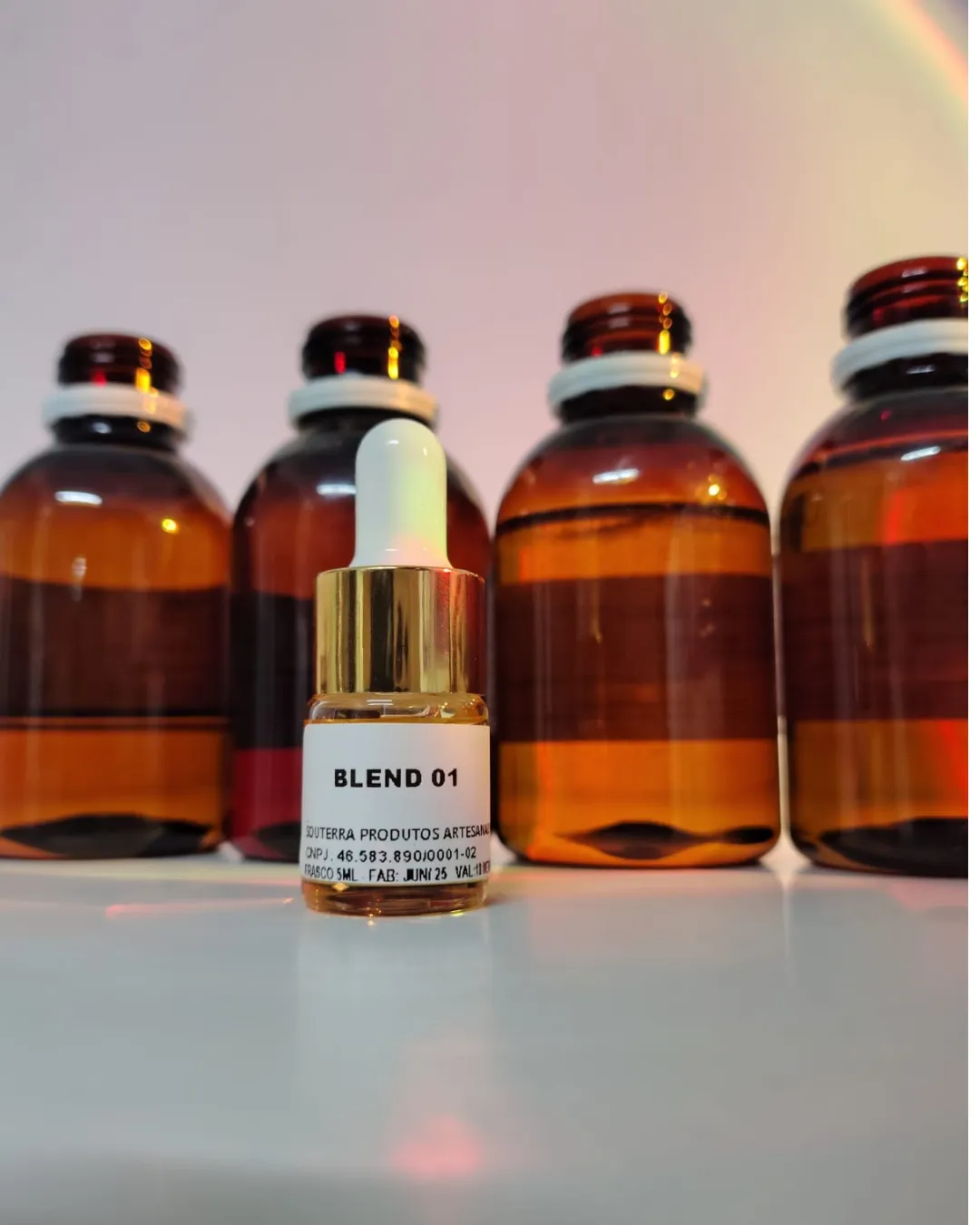 Frasco Blend 01 da SouTerra à frente dos galões de essências artesanais